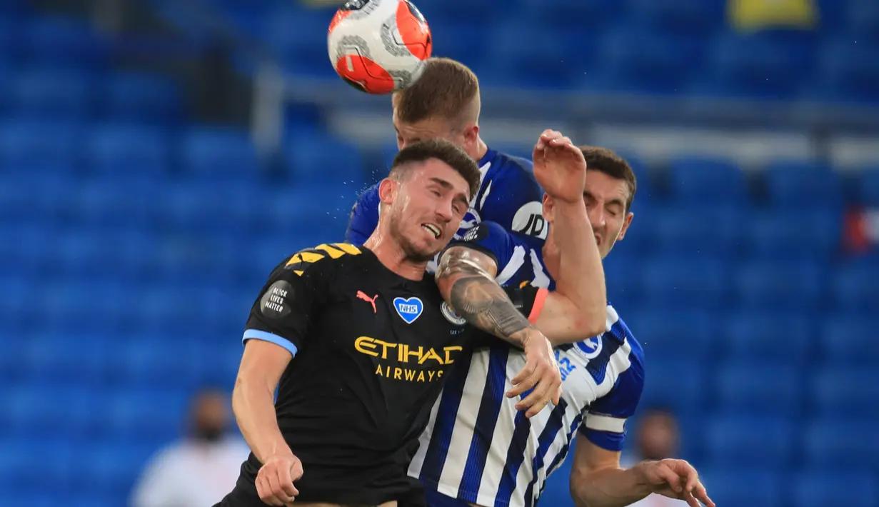 Bek Manchester City Aymeric Laporte melompat saat berebut bola dengan pemain Brighton and Hove Albion, Lewis Dunk pada Pekan ke-35 Liga Inggris di stadion The American Express, Minggu (12/7/2020). Manchester City berpesta gol di markas Brighton. (Adam Davy/Pool via AP)