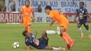 Striker PSIS Semarang, Hari Nur Yulianto, dijatuhkan gelandang Persija Jakarta, Novri Setiawan, pada laga Liga 1 di Stadion Sultan Agung, Bantul, Jumat (20/4/2018). PSIS kalah 1-4 dari Persija. (Bola.com/Ronald Seger)
