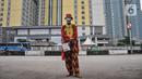 Badut melintas di dekat RSDC Wisma Atlet Kemayoran, Jakarta, Kamis (16/12/2021). Saat ini RSDC Wisma Atlet Kemayoran hanya digunakan untuk perawatan pasien Covid-19 dan satu tower dijadikan lokasi karantina atau isolasi terpusat bagi pekerja migran indonesia atau TKI. (merdeka.com/Iqbal S. Nugroho)