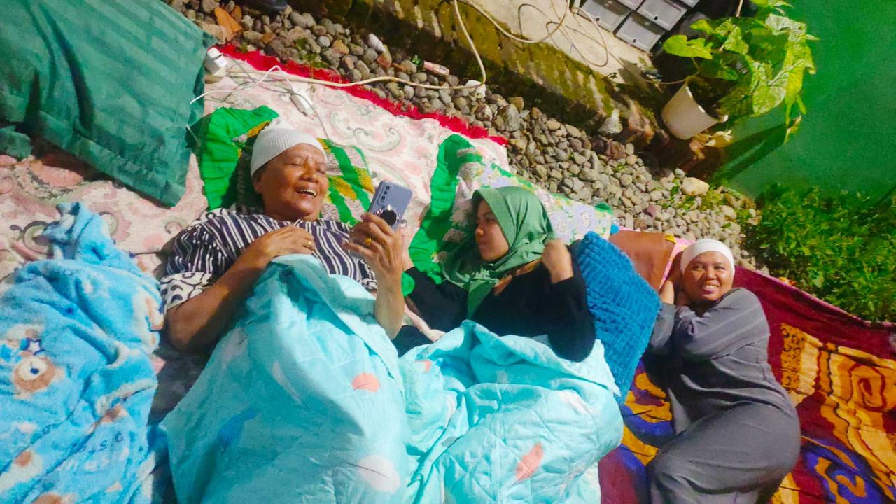 Emak-emak di Bawean nampak tersenyum saat bicara dengan kerabatnya melalui handphone. (Istimewa)