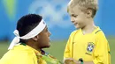 Neymar melakukan selebrasi bersama anaknya usai meraih medali emas pada final sepak bola melawan Jerman di Stadion Maracana, Rio de Janeiro, (21/8/2016) dini hari WIB. (AFP/Odd Andersen)