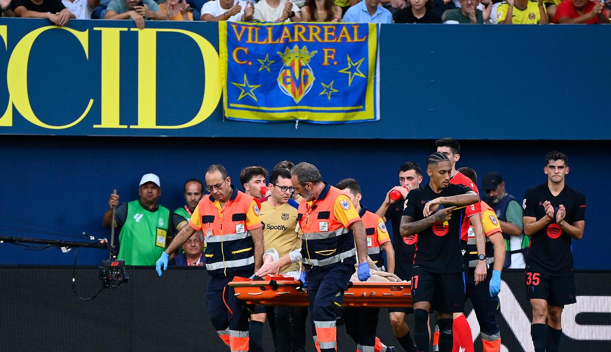 Marc-Andre Ter Stegen terpaksa meninggalkan lapangan menggunakan tandu karena cedera yang didapatkannya cukup parah saat Barcelona menghadapi Villarreal di Stadion La Ceramica pada Minggu (22/9/2024). (AFP/Jose Jordan)