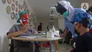 Tenaga kesehatan bertopeng superhero melakukan skrining kesehatan anak saat melayani vaksinasi anak usia 6-11 tahun di RSIA Tambak, Jakarta, Rabu (22/12/2021). Sebanyak 30 anak mengikuti vaksinasi yang menggunakan vaksin Sinovac tersebut. (Liputan6.com/Herman Zakharia)