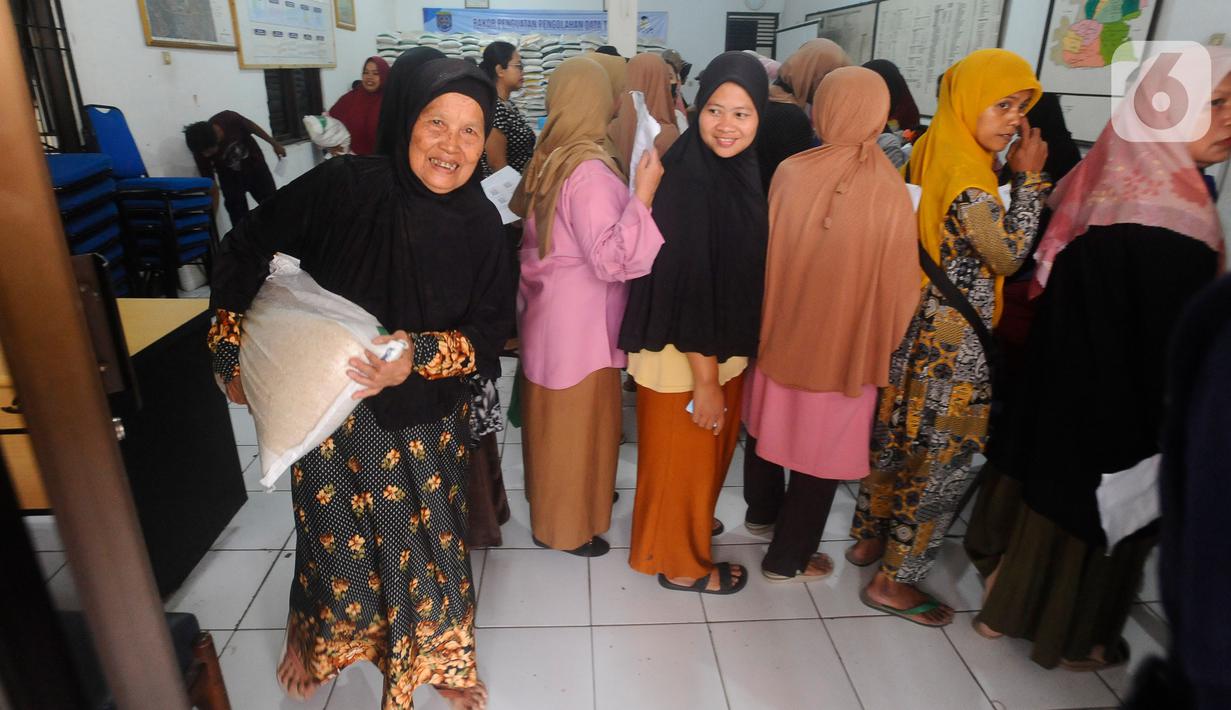 Keluarga penerima manfaat (KPM) membawa bantuan sosial pangan beras saat berlangsung penyaluran di kantor Kelurahan Meruyung, Depok, Sabtu  (11/5/2024). (merdeka.com/Arie Basuki)