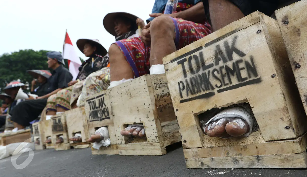 Sejumlah warga Petani Kendeng, Pati, Jawa Tengah menyemen kakinya di depan Istana Negara, Jakarta, Selasa (14 /3). Pada aksi ini di hari kedua ini jumlah petani yang mencor kakinya bertambah menjadi sebelas orang. (Liputan6.com/Helmi Afandi)