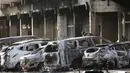 Petugas kepolisian memeriksa mobil yang hangus terbakar pasca teror di luar hotel Splendid, Ouagadougou , Burkina Faso, (16/1). Petugas berhasil merebut kembali lokasi dimana beberpa kelompok al Qaeda menyandera beberapa orang. (REUTERS / Joe Penney)