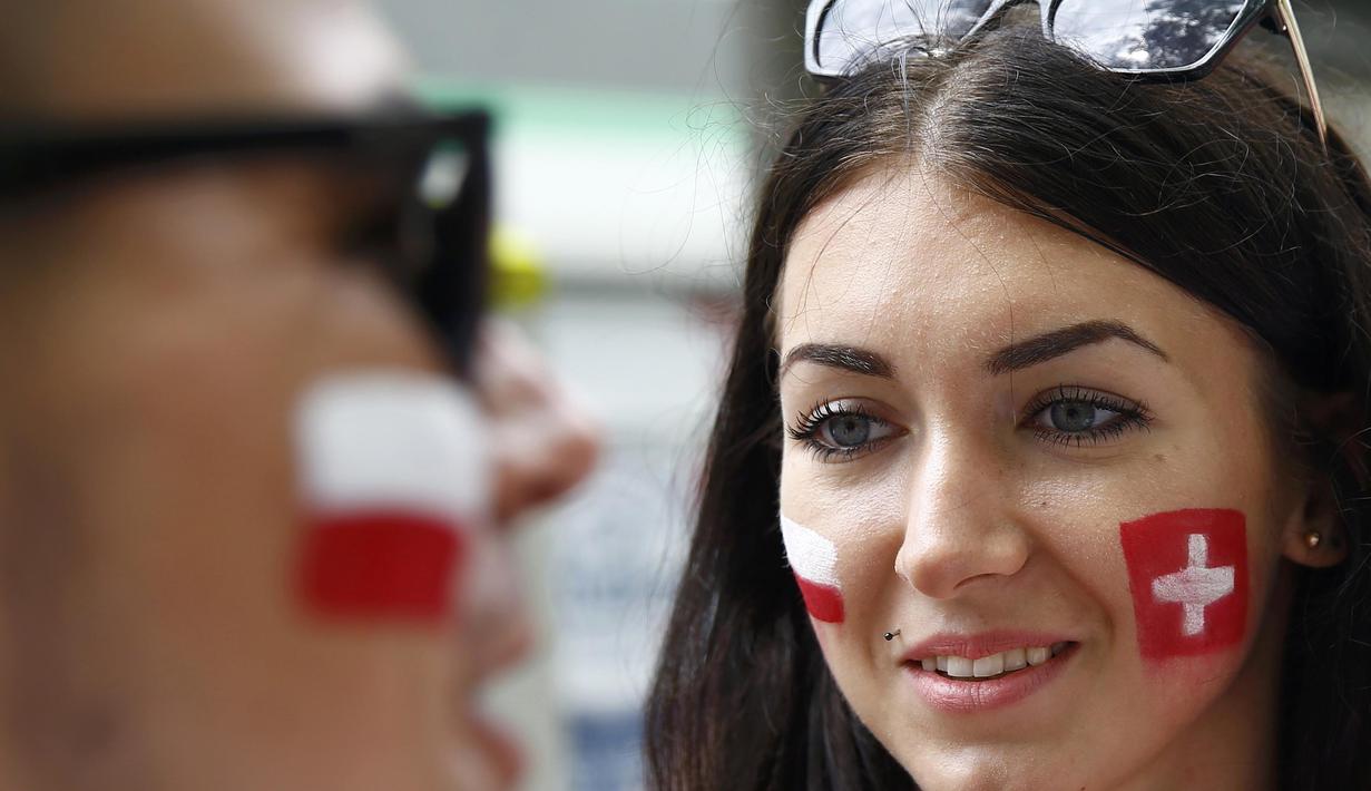 Fans cantik ini membuat bendera Polandia dan Swiss di kedua pipinya saat kedua tim bertemu pada babak 16 besar Piala Eropa 2016 di Stadion Geoffroy-Guichard, Saint-Etienne (26/6/2016) WIB.  (REUTERS/Wolfgang Rattay)