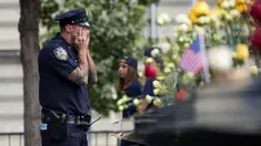 Petugas New York City Police Department (NYPD) mengusap wajahnya selama peringatan 16 tahun korban serangan 11 September di Museum dan Memorial Nasional 9/11, New York, Amerika Serikat, Senin (11/9). (Drew Angerer/Getty Images/AFP)