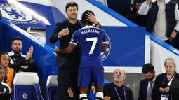 Pelatih Chelsea, Mauricio Pochettino, memeluk Raheem Sterling setelah laga melawan Luton Town di Stadion Stamford Bridge pada laga pekan ketiga Premier League, Sabtu (26/8/2023). Trigol Chelsea tercipta atas nama Raheem Sterling pada menit ke-17 dan 68', serta Nicolas Jackson menit ke-75. (AFP/Henry Nicholls)