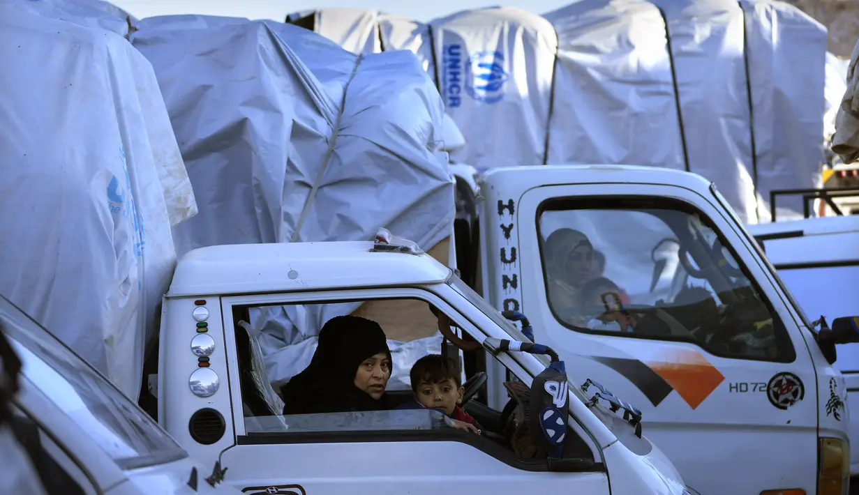 Di kota Arsal di timur laut, para pengungsi Suriah menumpuk barang-barang mereka di bagian belakang truk dan mobil. (AP Photo/Hussein Malla)