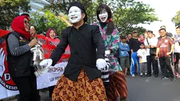 Penampilan  seniman pantomim dari Dewan Kesehatan Rakyat saat melakukan aksi teatrikal di CFD kawasan Senayan, Jakarta, Minggu (30/07). (Liputan6.com/Fery Pradolo)