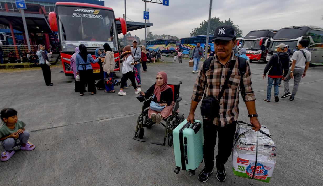 Peserta mudik gratis berjalan menuju bus di Terminal Pondok Cabe, Tangerang Selatan, Banten, Kamis (27/3/2025). (merdeka.com/Arie Basuki)