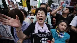 Dalam aksinya, para demonstran membawa plakat yang menuding kebijakan PM Jepang, Shinzo Abe, yang ingin memperluas peran militer sebagai bentuk fasisme, (30/6/2014). (REUTERS/Issei Kato)