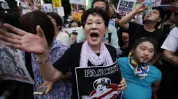 Dalam aksinya, para demonstran membawa plakat yang menuding kebijakan PM Jepang, Shinzo Abe, yang ingin memperluas peran militer sebagai bentuk fasisme, (30/6/2014). (REUTERS/Issei Kato)
