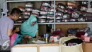 Seorang konsumen menggunakan jasa pencucian pakaian (laundry) di Jakarta, Selasa (12/7). Usaha pencucian pakaian mengalami peningkatan omset hingga 20% dibanding hari biasa setelah libur lebaran. (Liputan6.com/Faizal Fanani)