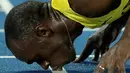 Sprinter Jamaika, Usain Bolt, mencium lintasan setelah meraih medali emas lari 200m putra Olimpiade Rio 2016 di Olympic Stadium, Rio de Janeiro, Brasil, (18/8/2016). (AP Photo/Matt Dunham)
