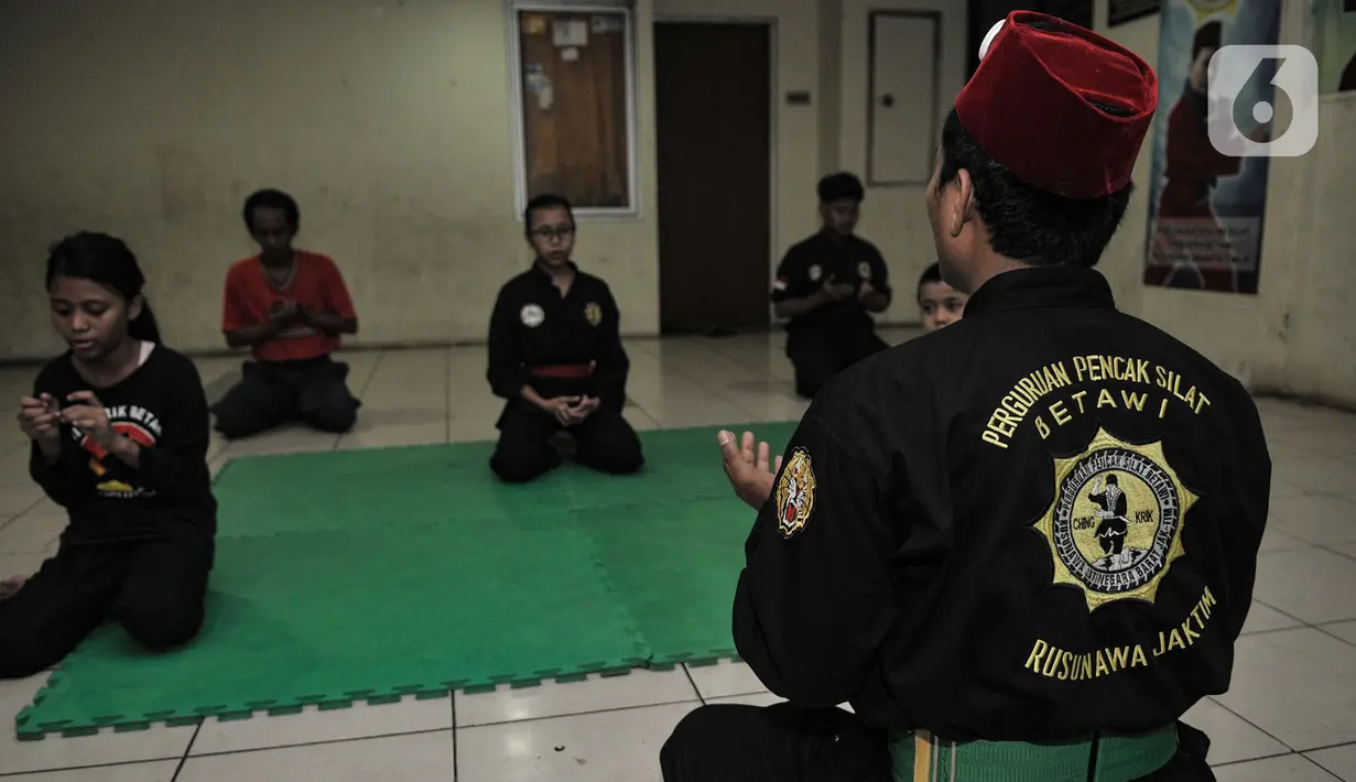 Iwan memimpin doa sebelum memulai latihan. Di aula yang tidak terlalu besar itu Iwan setidaknya telah melatih ratusan murid mayoritas anak-anak hingga remaja dan memenangi beberapa kejuaraan baik tingkat wilayah maupun Provinsi. (merdeka.com/Iqbal S Nugroho)