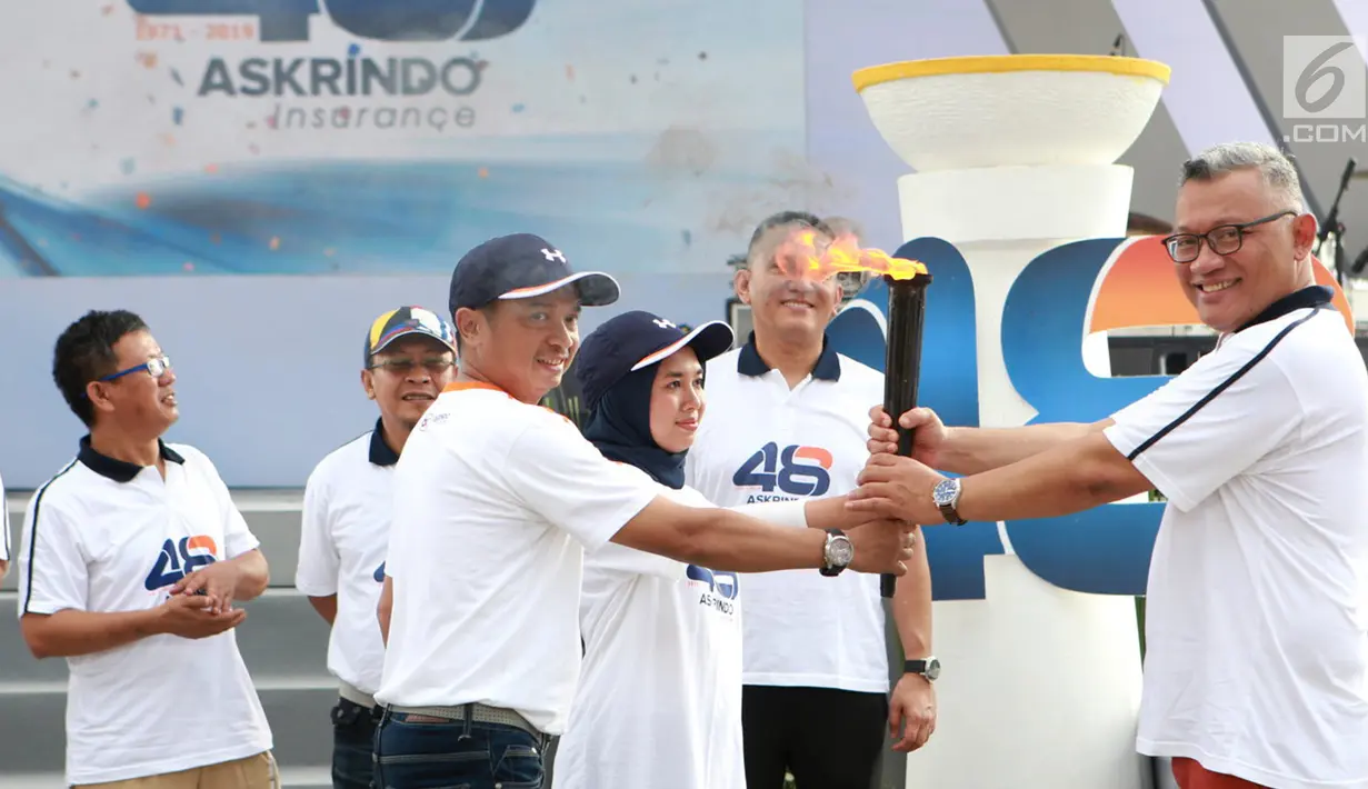 Dirut PT Askrindo, Andrianto Wahyu Adi (kanan) menerima obor Torch Relay pada acara HUT ke-48 Askrindo di Ancol Fantastique, Jakarta, Sabtu (6/4). Kegiatan mengusung tema "Satu Langkah Satu Tujuan Kita Tingkatkan Daya Saing Perusahaan”. (Liputan6.com/HO/Iqbal)