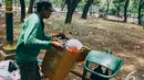 Seorang petugas sedang mengangkut sampah di kawasan Monas, Jakarta, Senin (27/10/2014). (Liputan6.com/Faizal Fanani)