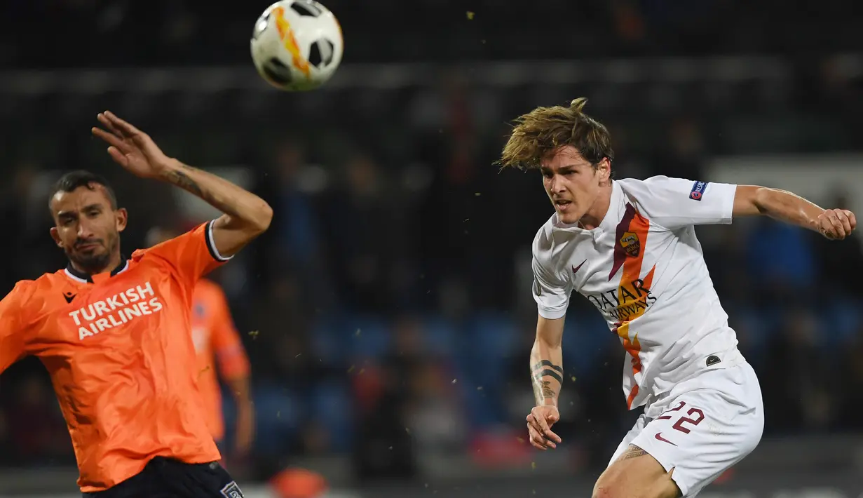Gelandang AS Roma, Nicolo Zaniolo (kanan) berebut bola dengan pemain Istanbul Basaksehir Mehmet Topal pada laga kelima Grup J Liga Europa 2019-2020 di stadion Fatih Terim, Kamis (28/11/2019). AS Roma menang meyakinkan dengan skor 3-0.  (Ozan KOSE / AFP)