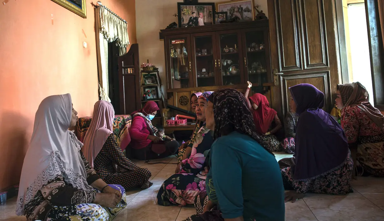 Kerabat Letnan Satu Muhammad Imam Adi yang bertugas dalam kapal selam KRI Nanggala 402 berkumpul di rumah keluarga di Pasuruan, Jawa Timur, Minggu (25/4/2021). KRI Nanggala 402 hilang kontak di lepas pantai Bali pada 21 April dan kemudian dinyatakan tenggelam dengan 53 awak. (Juni Kriswanto/AFP)