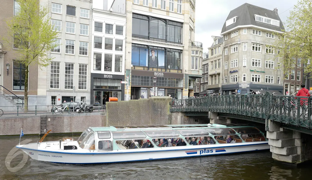 Warga menaiki perahu saat melintasi kanal di kawasan Amsterdam, Belanda (April 2017). Meskipun pada abad ke-19 kotor dan dipenuhi limbah, kini kanal-kanal di Belanda menjadi salah satu objek wisata terkenal di dunia. (Liputan6.com/Immanuel Antonius)
