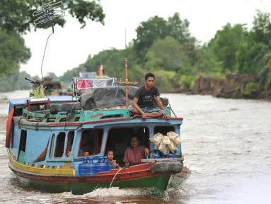 Warga menggunakan perahu motor sebagai transportasi alternatif dari Kota Palembang menuju Ogan Komering Ilir (OKI) di Sungai Baung, Sumsel, Kamis (24/30). Transportasi ini telah menjadi andalan masyarakat sejak lama. (Liputan6.com/Gempur M Surya)