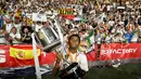 Pemain Real Madrid, Rodrygo, saat mengangkat piala Copa del Rey 2022/2023 dihadapan para penonton setelah berhasil mengalahkan Osasuna 2-1 dalam partai final di La Cartuja, Minggu (7/5/2023). Berkat dua golnya ke gawangOsasuna, Real Madrid berhasil mendapatkan gelar Copa del Rey ke-20. (AFP/Javier Soriano)