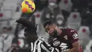 Penyerang Juventus Moise Kean (kiri) berebut bola dengan bek Torino Koffi Djidji dalam pekan 26 Serie A Liga Italia di Allianz Stadium, Sabtu (19/2/2022) dinihari WIB. Juventus ditahan imbang Torino 1-1. (Filippo MONTEFORTE / AFP)