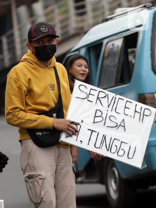 Penjual jasa perbaikan telepon genggam menawarkan jasa di pinggir jalan Mayjen Sutoyo depan Mall Pusat Grosir Cililitan (PGC), Jakarta, Rabu (14/7/2021). Imbas dari penutupan Mall PGC selama PPKM Darurat Jawa-Bali, mereka terpaksa menawarkan jasa di pinggir jalan. (Liputan6.com/Helmi Fithriansyah)