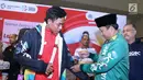 Menpora, Imam Nahrawi (kanan) memakaikan jaket Asian Games kepada juara dunia lari 100m putra U-20, Lalu Muhammad Zohri saat penyambutan di Terminal 3 Bandara Soetta, Tangerang, Selasa (17/7). (Liputan6.com/Helmi Fithriansyah)