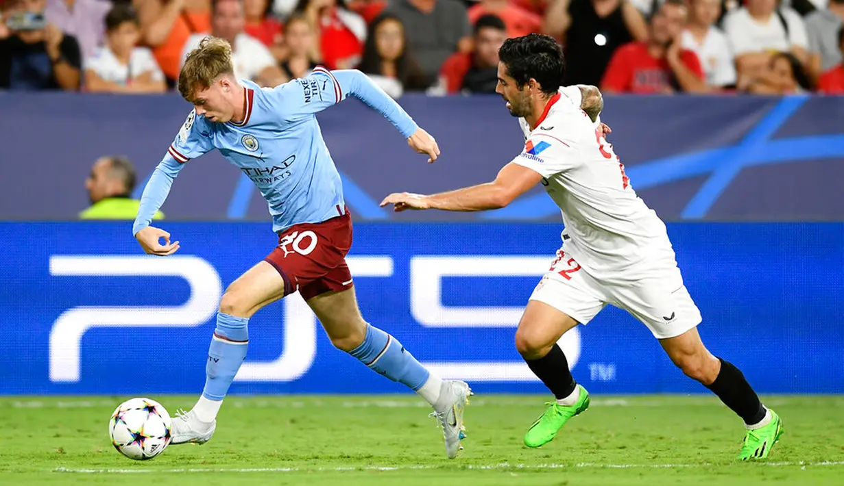 Pemain Manchester City Cole Palmer berlari menjauh dari pemain Sevilla Isco pada pertandingan sepak bola grup G Liga Champions di Seville, Spanyol, 6 September 2022. Manchester City menang 4-0. (AP Photo/Jose Breton)