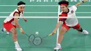 <p>Pemain ganda putri Indonesia, Apriyani Rahayu (kiri) dan Siti Fadia Silva Ramadhanti berusaha mengembalikan bola saat menghadapi wakil China, Chen Qingchen/Jia Yifan pada laga kedua Grup A nomor ganda putri cabor bulu tangkis Olimpiade Paris 2024 di Porte de la Chapelle Arena, Prancis, Minggu (28/7/2024). (AFP/David Gray)</p>