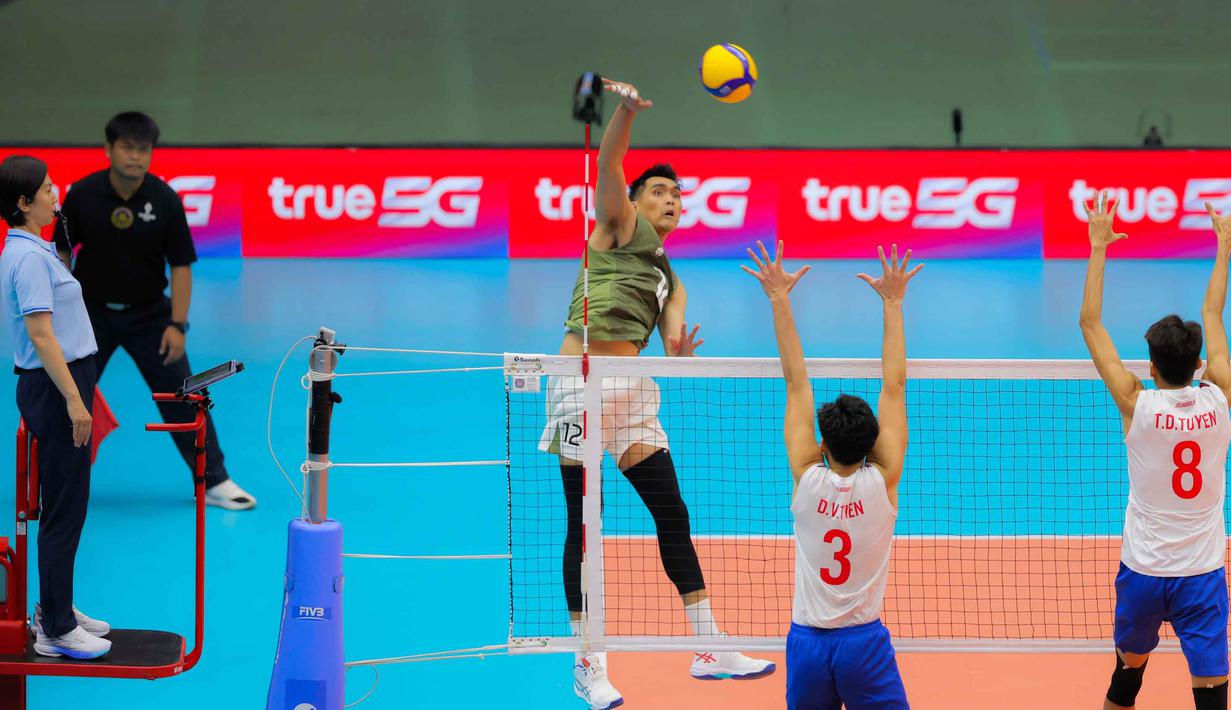 Tampil di bawah tekanan Vietnam, Timnas voli putra Indonesia berhasil bermain lepas dan menutup set keempat dengan skor 25-19 dan kelima (15-10). Tampak dalam foto, pemain voli putra Indonesia, Rivan Nurmulki (kiri) melakukan smash saat melawan Vietnam di babak semifinal SEA Games 2025 di Indoor Stadium Huamark, Bangkok, Thailand, Kamis (18/12/2025). (Bola.com/Bagaskara Lazuardi)