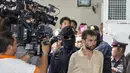 Petugas menggiring tersangka yang terlihat tegang ke dalam Pengadilan Bangkok, Thailand, Sabtu (5/9/2015). Tim forensik gagal menemukan kaitan pemboman Bangkok dengan dua pelaku serangan mematikan di Kuil Erawan, Thailand. (REUTERS/Athit Perawongmetha)