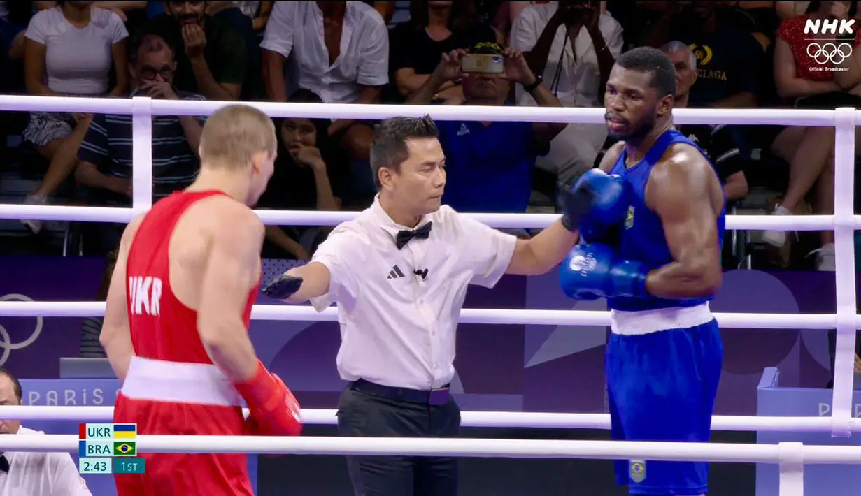 Wasit Indonesia, Muhammad Arisa Putra Pohan saat memimpin pertandingan semifinal tinju Olimpiade Paris 2024 antara petinju Ukraina, Oleksandr Khyzhniak (kiri) melawan petinju Brasil, Wanderley De Souza di North Paris Arena, Villepinte, Prancis, Jumat (02/08/2024). (Dok. NOC Indonesia)