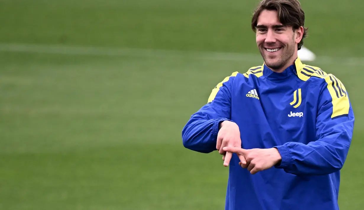 Penyerang Juventus, Dusan Vlahovic tersenyum saat ambil bagian dalam sesi latihan di tempat latihan Continassa di Turin, Italia (15/3/2022). Pada leg pertama Juventus bermain imbang dengan Villarreal 2-2. (AFP/Marco Bertorello)