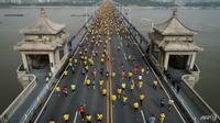 Pelari maraton Wuhan menyeberangi jembatan Sungai Yangtze pada tahun 2018. Acara tahun ini ditunda dalam waktu singkat karena kekhawatiran COVID-19. (Foto: AFP)