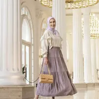 Kombinasi tiered skirt warna ungu yang dipadu puff sleeves top warna putih tulang dan hijab segi empat warna lilac ini membuat penampilan Dwi terlihat manis. (Instagram/dwihandaanda).