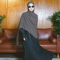 Dress panjang plisket hitam dipadukan kerudung coklat panjang. Tampil semakin bergaya dengan kacamata hitamndan sepatu oxfordnya. [@natasharizkynew]