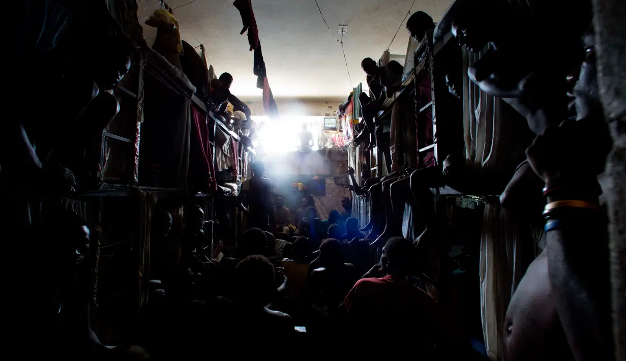 Para tahanan saat menonton televisi di dalam selnya di Lapas Nasional di pusat kota Port-au-Prince, Haiti, (13/2). Banyaknya narapidana yang belum menjalani sidang putusan tetapi harus ditahan membuat kamar tahanan penuh. (AP Photo/Dieu Nalio Chery)