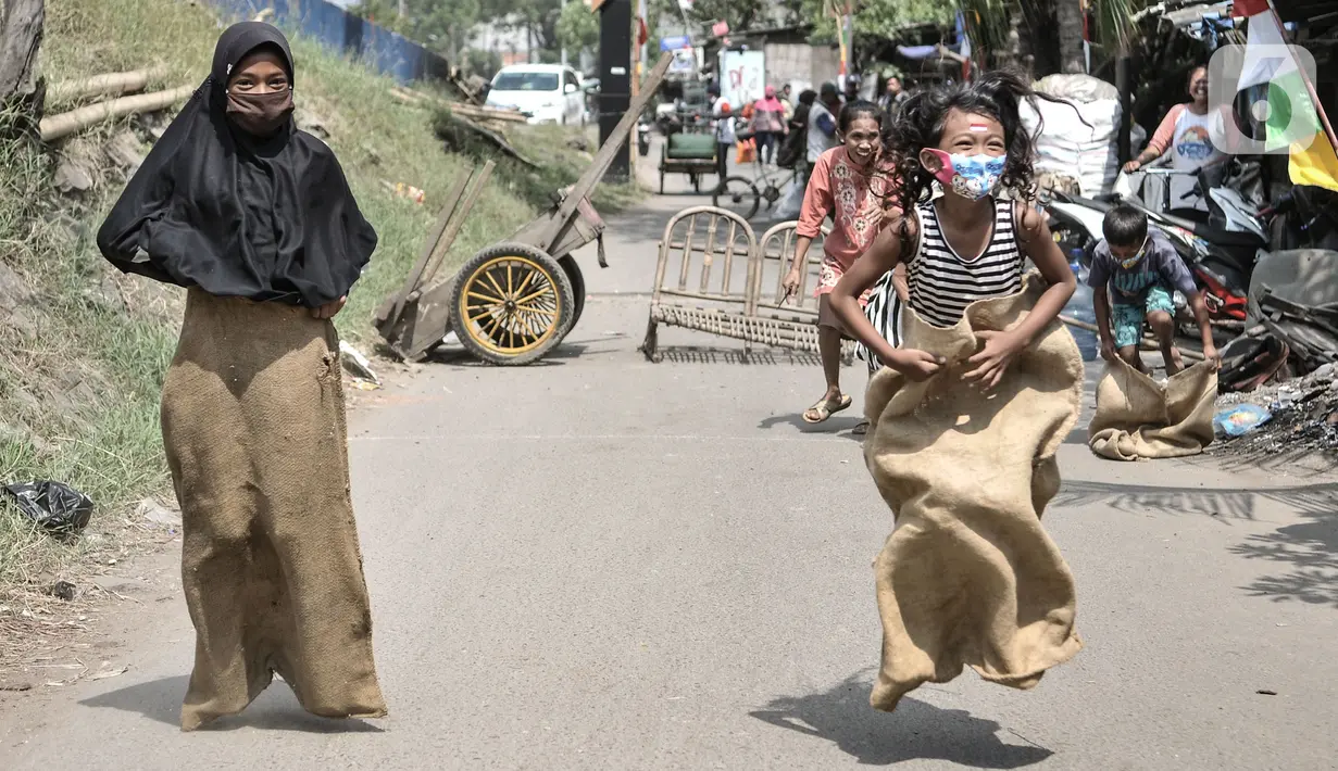 Anak-anak mengikuti lomba balap karung memperingati HUT ke-75 RI di Kampung Nelayan, Cilincing, Jakarta, Senin (17/8/2020). Meski dilarang menggelar perlombaan akibat Covid-19, warga di Kampung Nelayan tetap mengadakan lomba 17-an walaupun hanya beberapa jenis. (merdeka.com/Iqbal Nugroho)