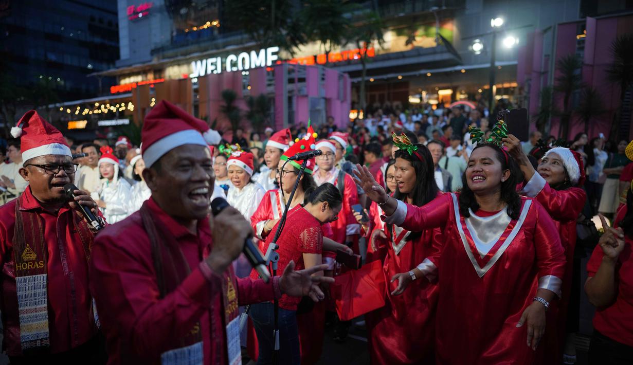 Peserta Christmas Carol menyanyi dengan mengenakan busana bernuansa Natal yang didominasi warna merah, hijau, dan putih. Tampak dalam foto, Umat Kristiani menyanyikan lagu-lagu Natal di Jakarta, Indonesia, Selasa, 23 Desember 2025. (AP Photo/Dita Alangkara)