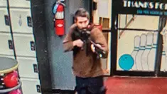 Dalam gambar yang diambil dari video yang dirilis oleh Kantor Sheriff Androscoggin County, seorang pria bersenjata tak dikenal menodongkan pistol saat memasuki Sparetime Recreation di Lewiston, Maine, Amerika Serikat, Rabu (25/10/2023). Polisi Negara Bagian Maine memerintahkan penduduk di kota terbesar kedua di negara bagian itu untuk berlindung di tempat karena tersangka masih buron. (Androscoggin County Sheriff's Office via AP)