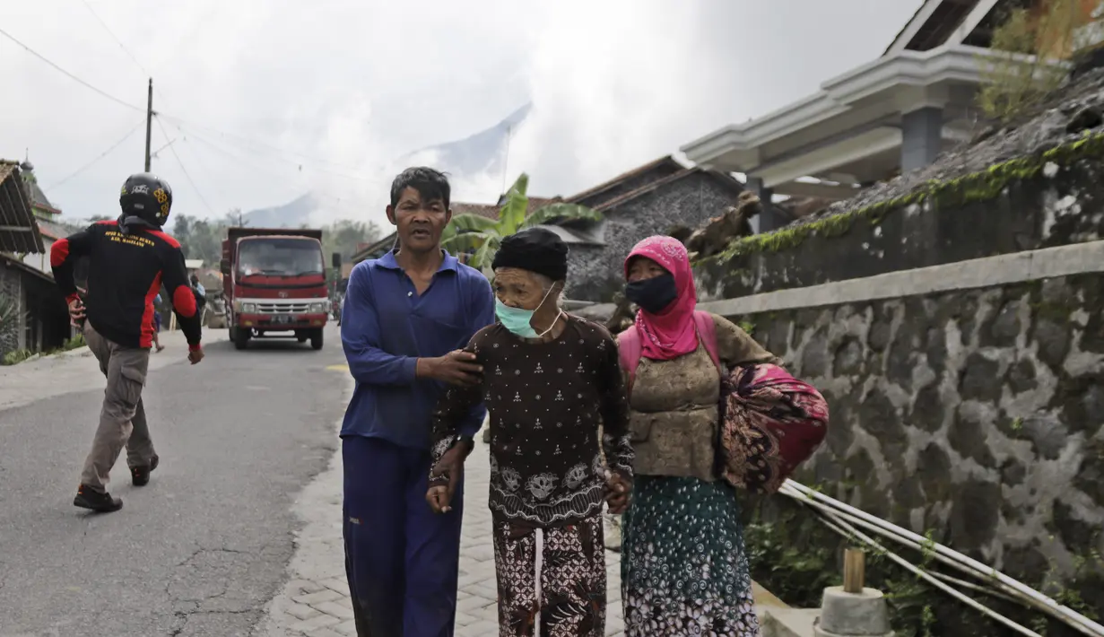 Lansia berjalan mobil bak terbuka yang menunggu saat dievakuasi dari rumah mereka di lereng Gunung Merapi, di Krinjing, Jawa Tengah, Jumat (6/11/2020). Evakuasi dilakukan bagi warga lereng Merapi menyusul peningkatan status aktivitas vulkanik gunung tersebut. (AP Photo/Taufiq Rozzaq)