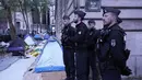 Petugas polisi berdiri di kamp darurat selama operasi pembersihan di Paris, Selasa (30/4/2023). (AP Photo/Michel Euler)