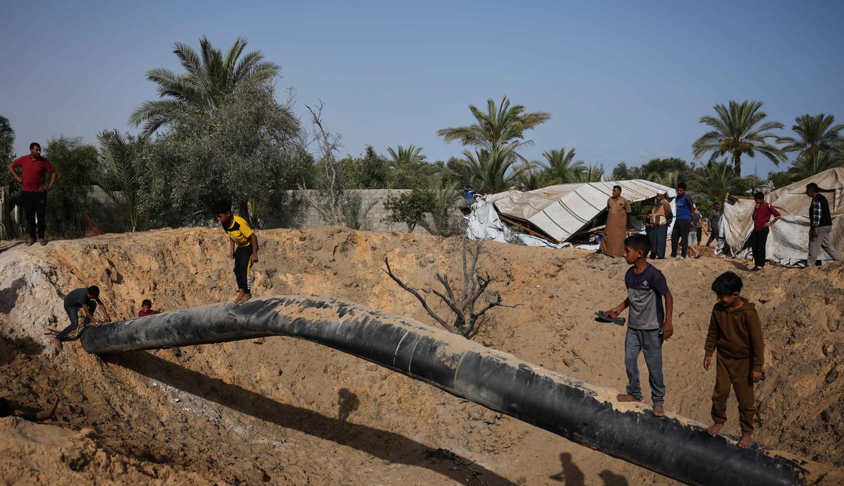 Warga Palestina memeriksa kerusakan akibat serangan Israel di Khan Younis, Jalur Gaza selatan, Selasa 19 Mei 2026. (AP Photo/Abdel Kareem Hana)