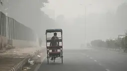 Penarik becak menembus kabut asap pekat yang menyelimuti jalan di New Delhi, Minggu (3/10/2019). Ibu Kota dari India tersebut sedang dilanda polusi udara yang sangat buruk sekaligus beracun pekan ini. (Photo by Sajjad  HUSSAIN / AFP)