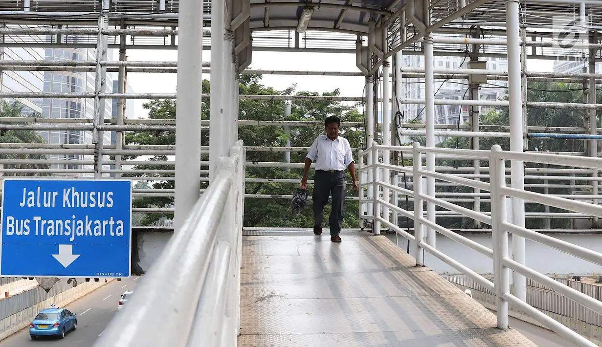 Pejalan kaki melintasi JPO Gelora Bung Karno di Jakarta, Kamis (3/5). Untuk mendukung penyelenggaraan Asian Games, Pemprov DKI Jakarta berencana merenovasi 12 JPO di kawasan Jalan Sudirman hingga MH Thamrin. (Liputan6.com/Immanuel Antonius)
