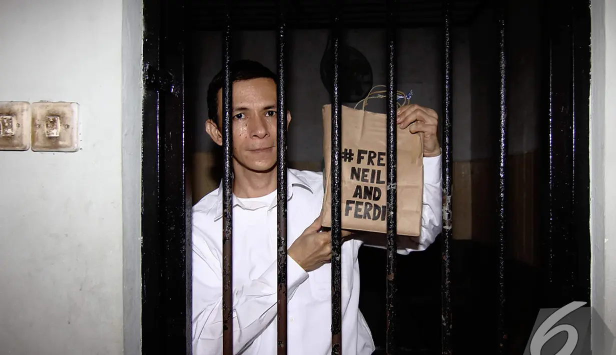 Ferdinant Tjiong memperlihatkan tas kardus bertuliskan #Free Neil and Ferdi saat akan menjalani sidang perdana di Pengadilan Negeri Jakarta Selatan, Selasa (2/12/2014). (Liputan6.com/Faizal Fanani)